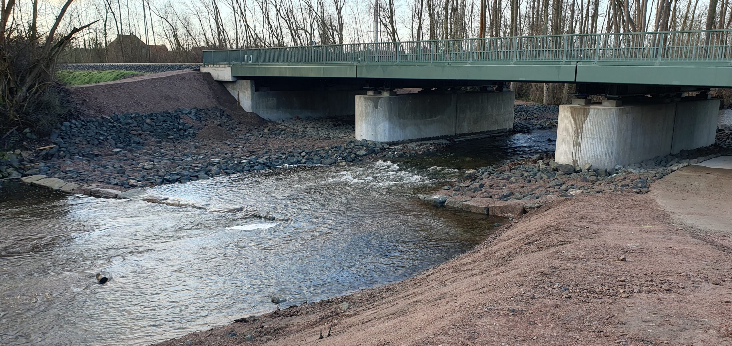 Eine neue Bahnbrücke führt über einen Fluss.